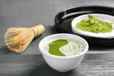 Chawan with fresh matcha tea and chasen on table