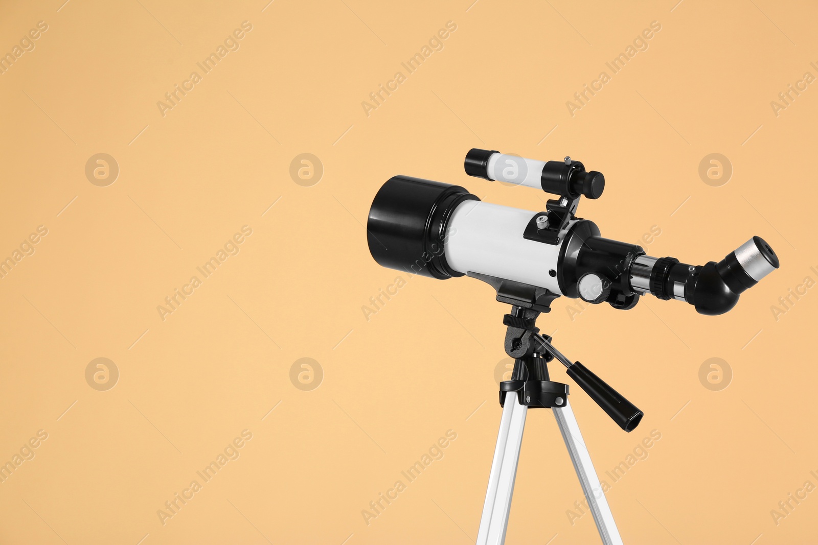 Photo of Tripod with modern telescope on beige background, space for text