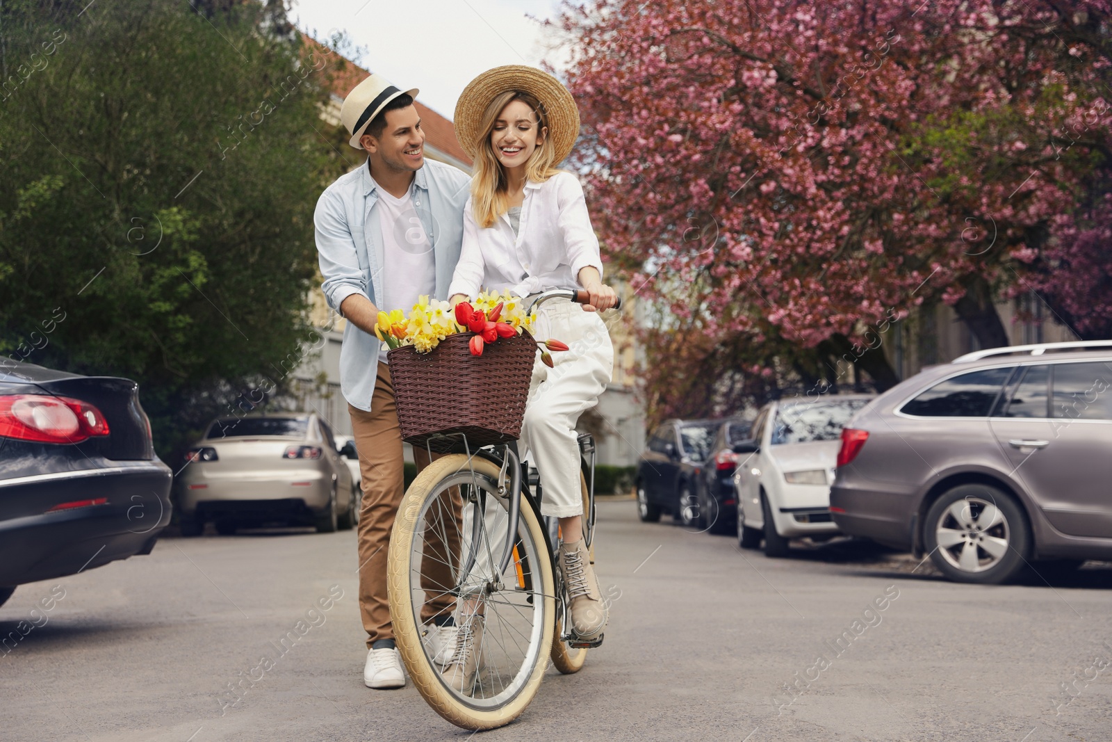 Photo of Lovely couple with bicycle and flowers on city street