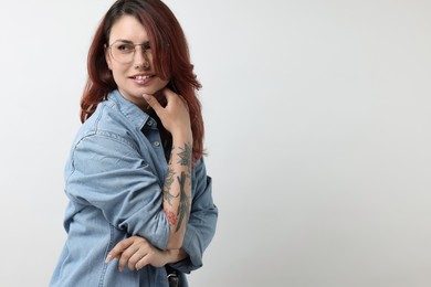 Photo of Portrait of beautiful tattooed woman on gray background, space for text