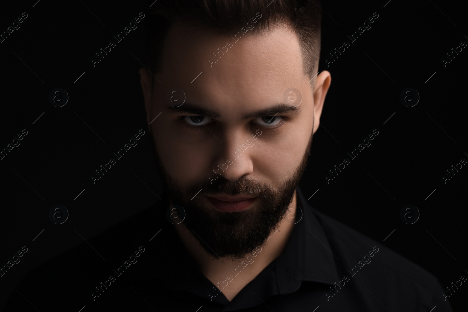 Photo of Evil eye. Man with scary eyes on black background