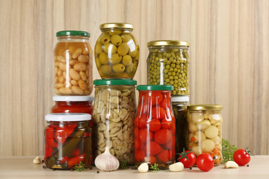 Jars of pickled vegetables on wooden table