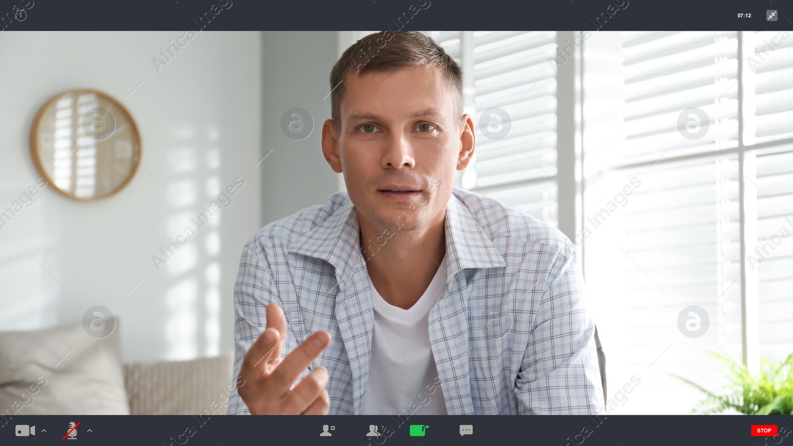 Image of Man communicating with coworkers from home using video chat, view through camera