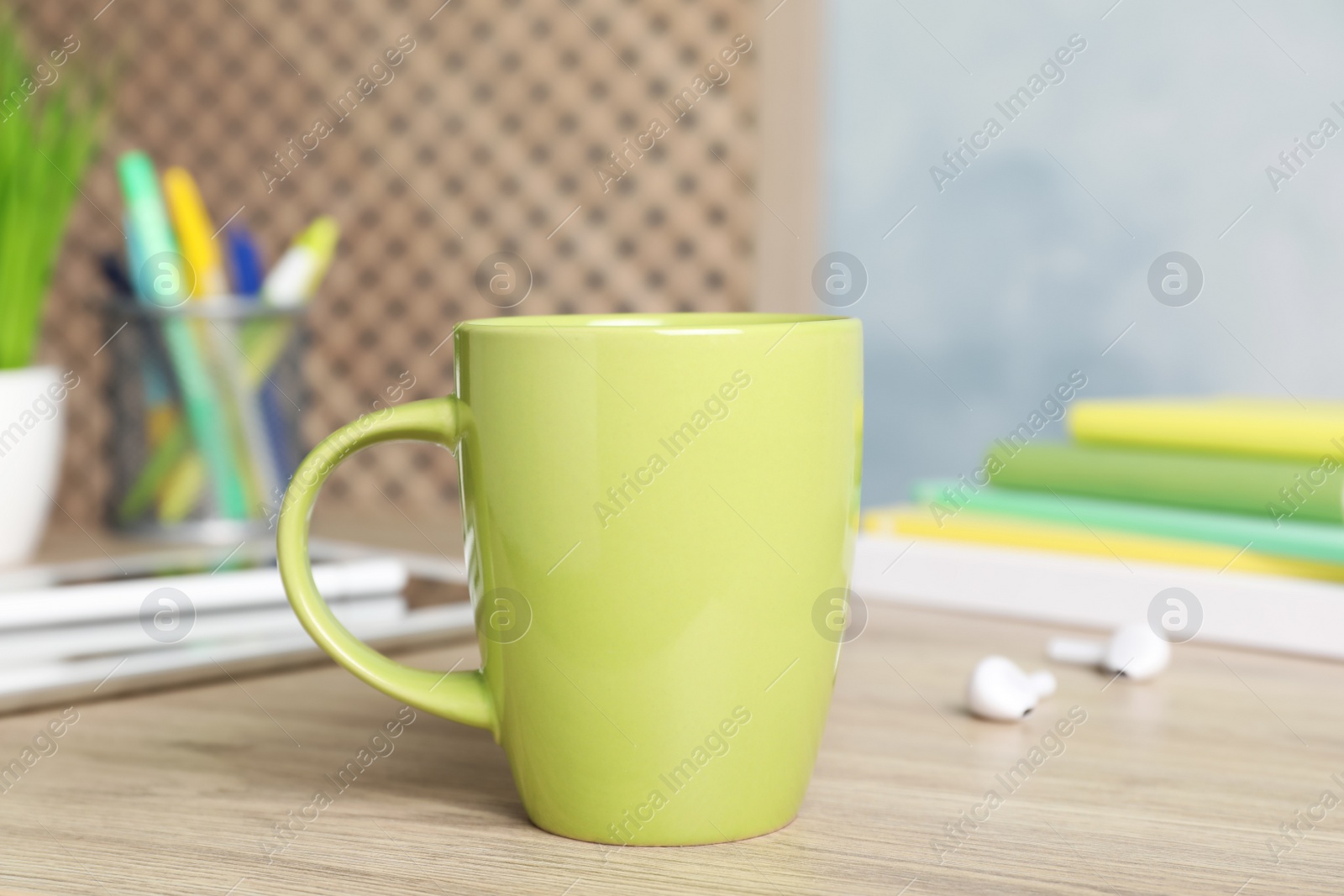 Photo of Coffee Break at workplace. Cup of hot drink on wooden table