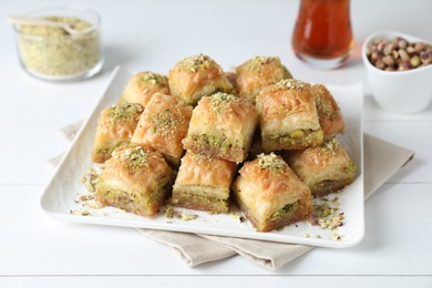 Delicious fresh baklava with chopped nuts on white wooden table. Eastern sweets