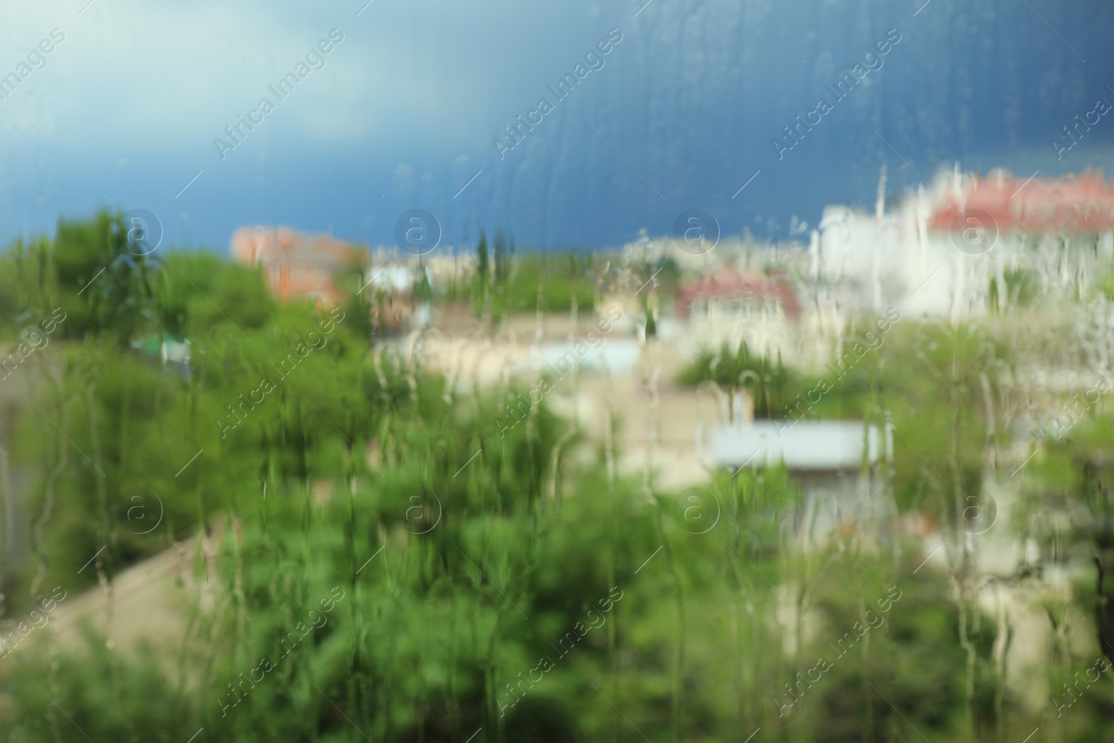 Photo of Blurred city view from window on rainy day