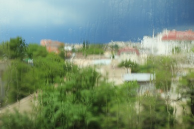 Photo of Blurred city view from window on rainy day