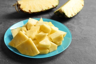 Plate with fresh sliced pineapple on table