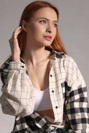 Photo of Beautiful young woman in stylish shirt on gray background