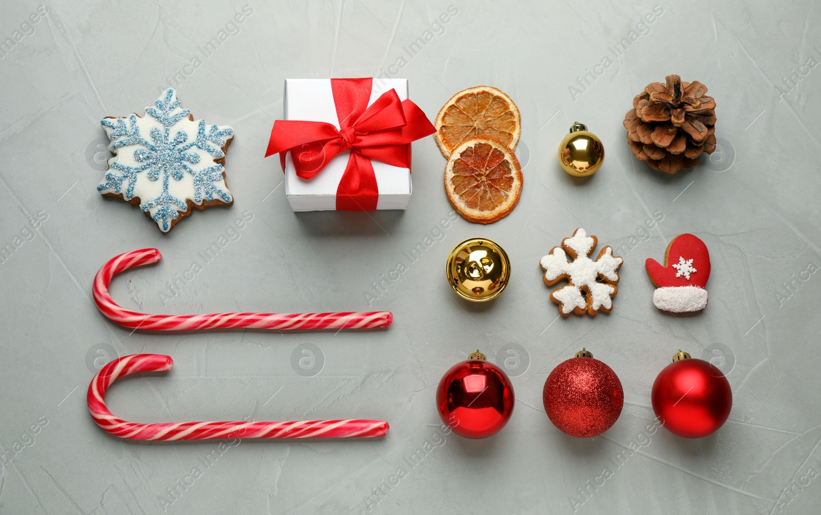 Photo of Flat lay composition with tasty candy canes and Christmas decor on grey table