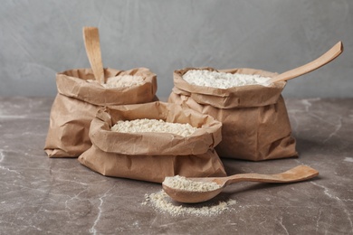 Photo of Paper bags with different types of flour on table