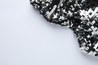 Photo of Beautiful shiny sequin fabric on white background, top view. Space for text