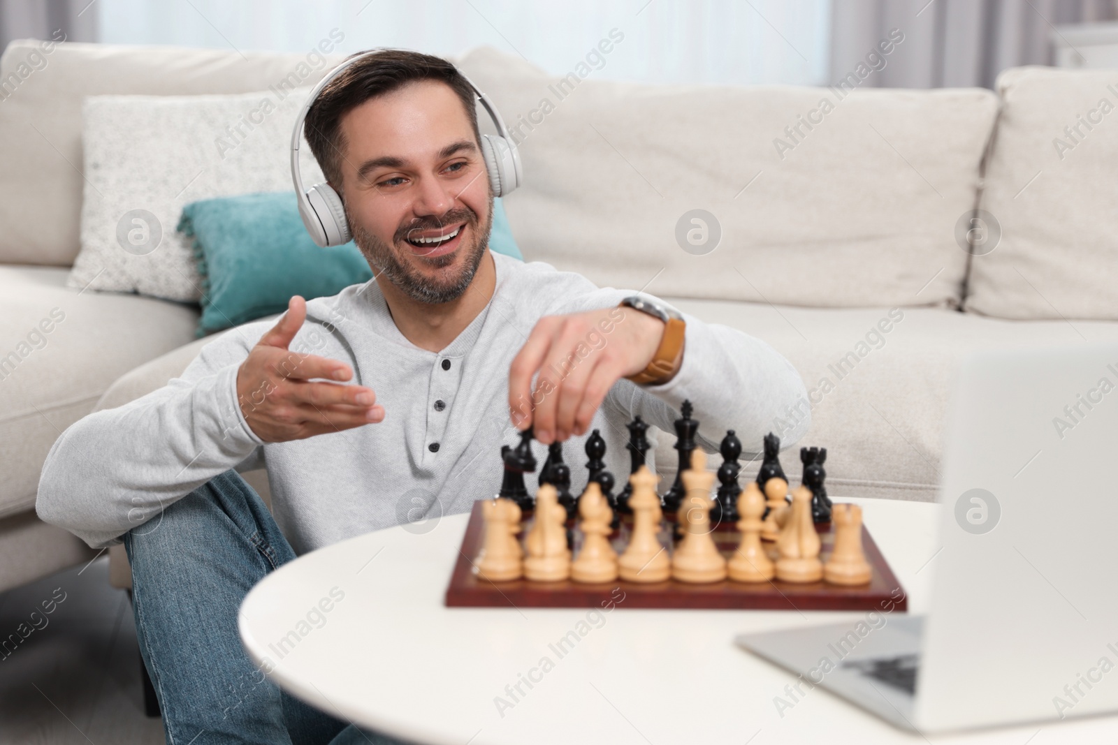 Photo of Teacher near chessboard conducting online lesson at home. Time for hobby