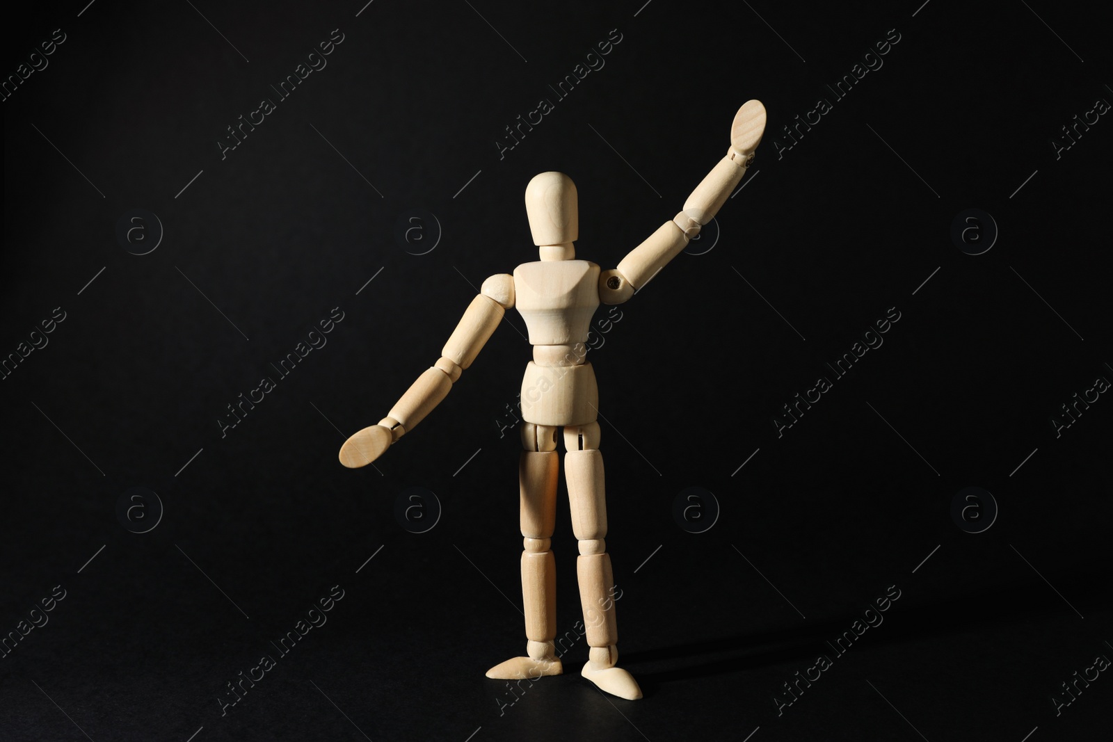 Photo of Wooden human model on black background. Mini mannequin