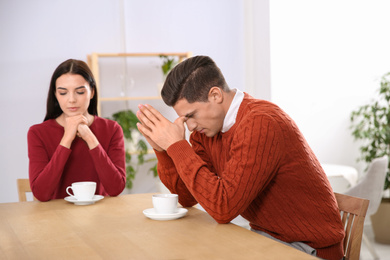 Couple with relationship problems at table in cafe