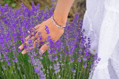 Photo of Woman in lavender field on summer day, closeup