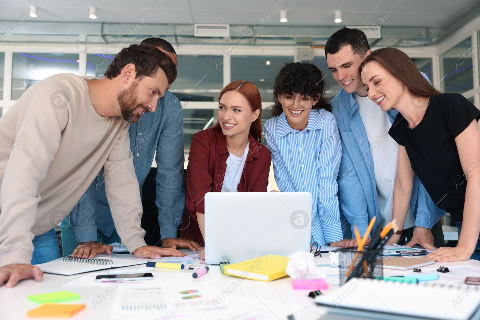 Photo of Team of employees working together at table in office. Startup project