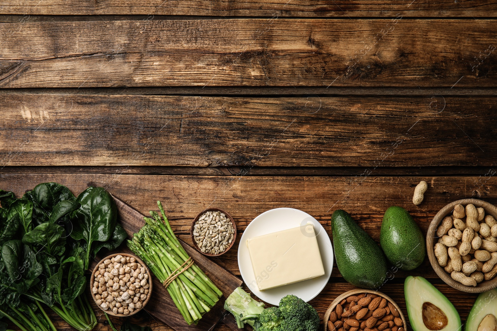 Photo of Different products rich in vitamin E on wooden table, flat lay. Space for text