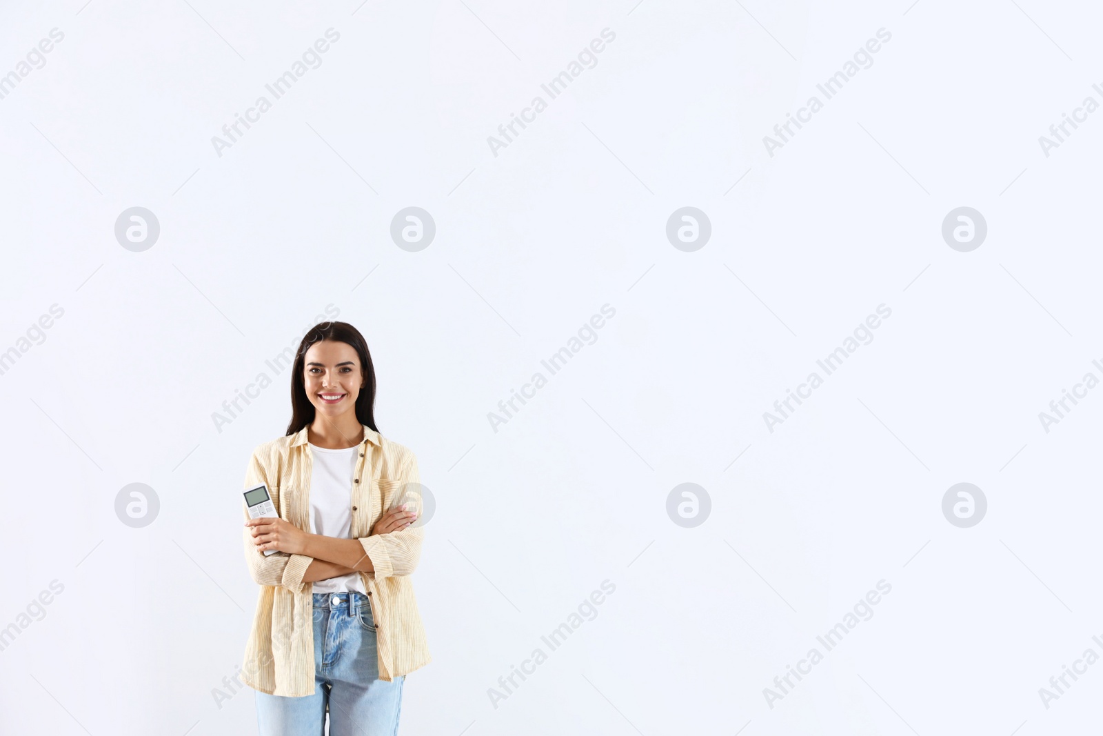 Photo of Young woman with air conditioner remote on white background