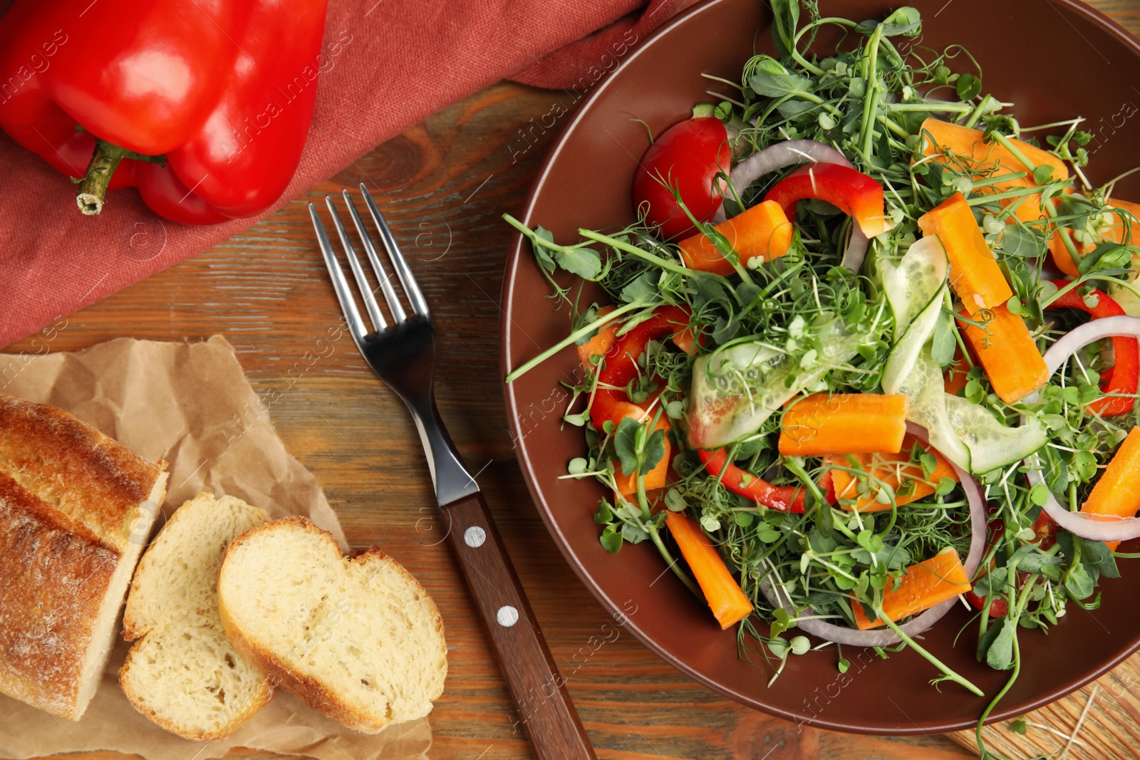 Photo of Delicious vegetable salad with microgreen served on wooden table, flat lay