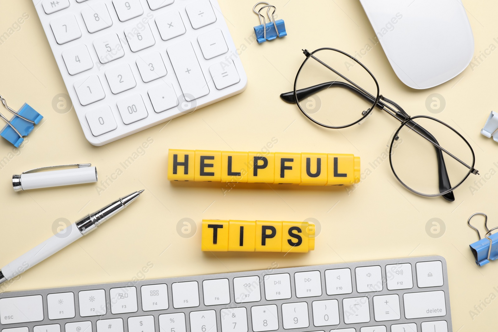 Photo of Flat lay composition with phrase Helpful Tips made of yellow cubes on beige background