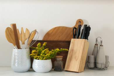 Photo of Wooden kitchenware and mimosa flowers on countertop indoors