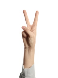 Photo of Young woman showing victory gesture on white background