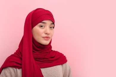 Photo of Portrait of Muslim woman in hijab on pink background, space for text