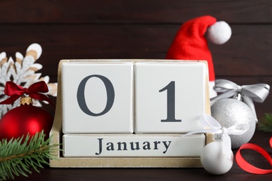 Photo of Block calendar and Christmas decor on wooden table. New Year celebration
