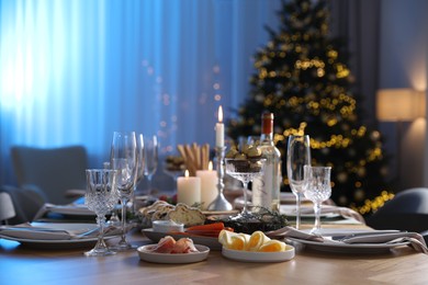 Christmas table setting with festive decor and dishware in room