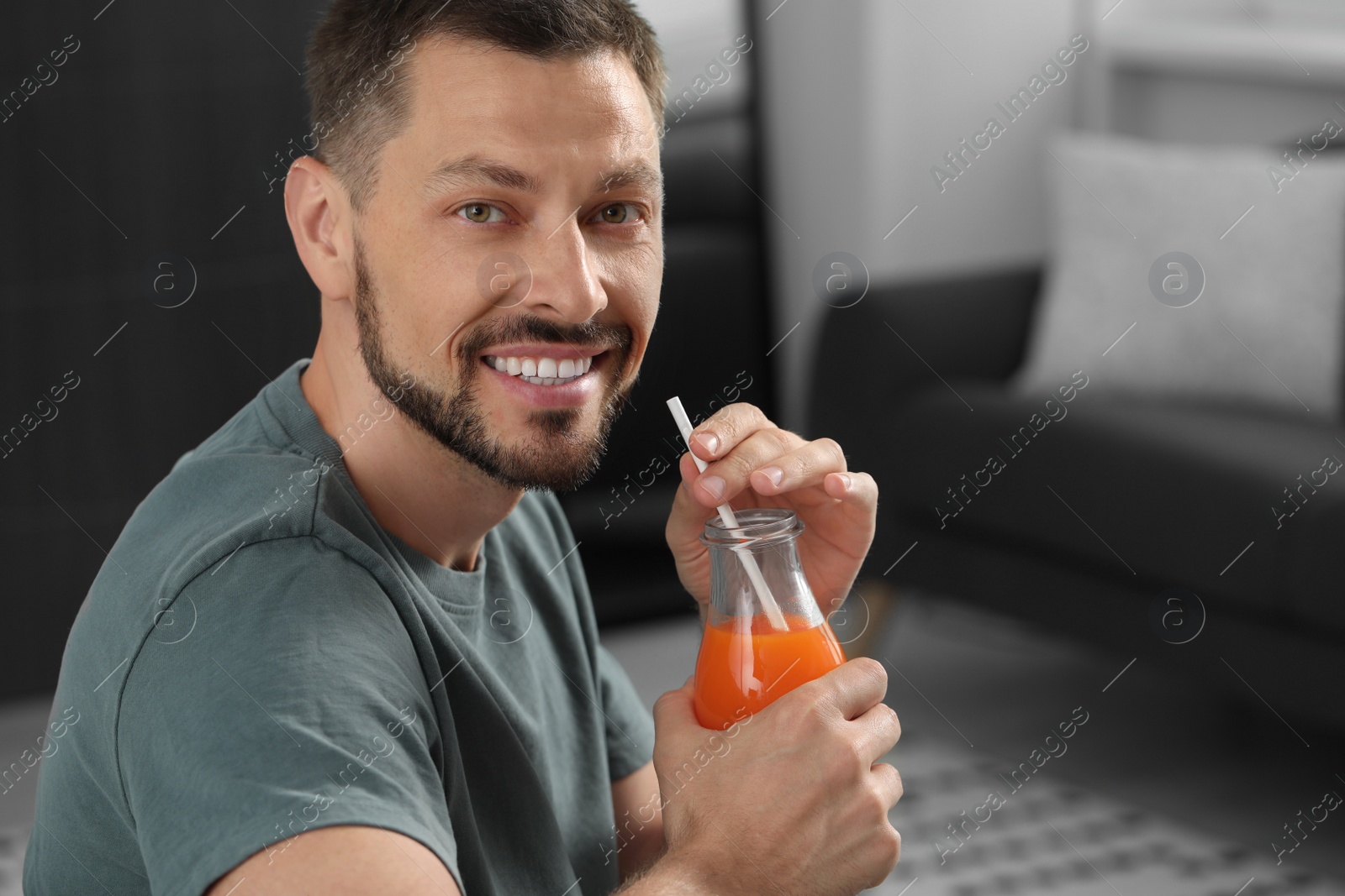 Photo of Man holding bottle of delicious juice at home