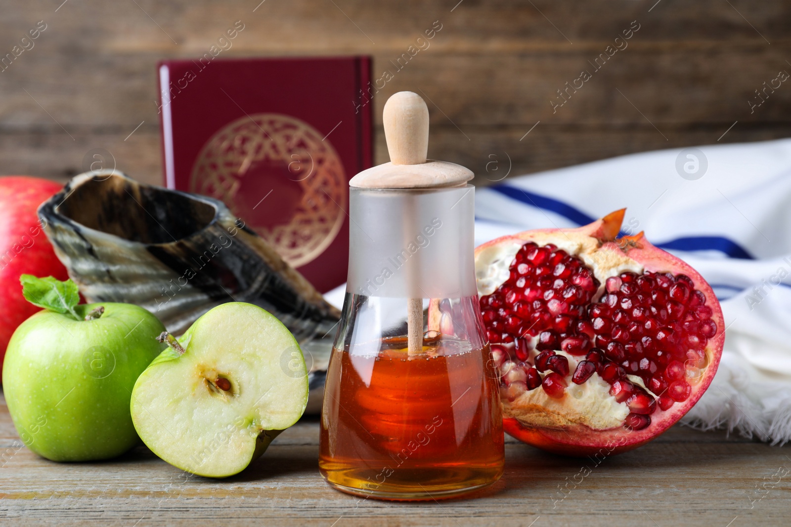 Photo of Honey, pomegranate, apples, shofar and Torah on wooden table. Rosh Hashana holiday