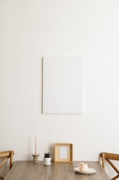 Photo of Room interior with dining table, wooden chairs and poster