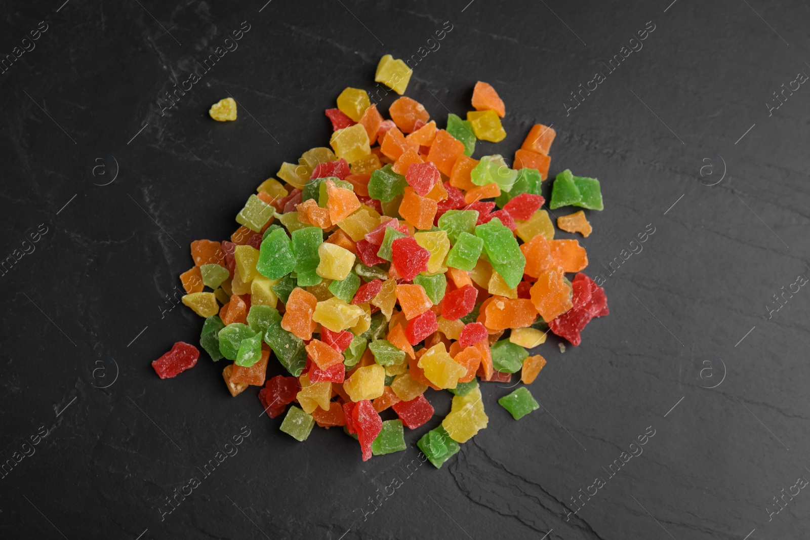 Photo of Mix of delicious candied fruits on black table, flat lay