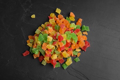 Mix of delicious candied fruits on black table, flat lay