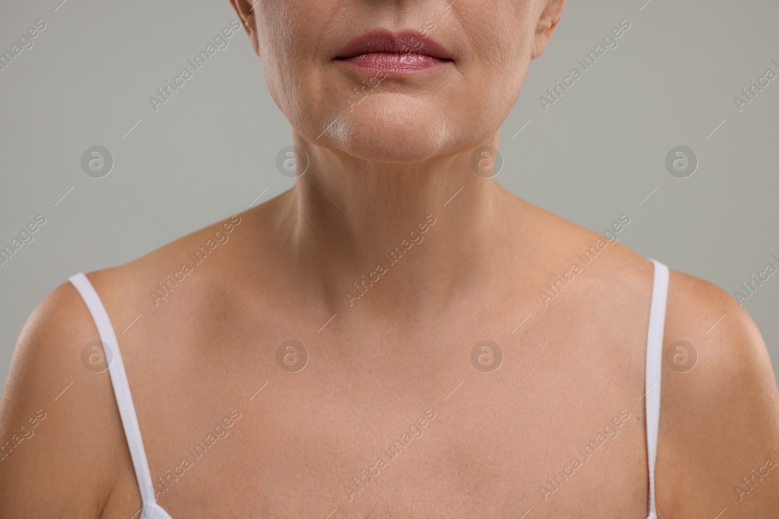 Photo of Mature woman with healthy skin on grey background, closeup