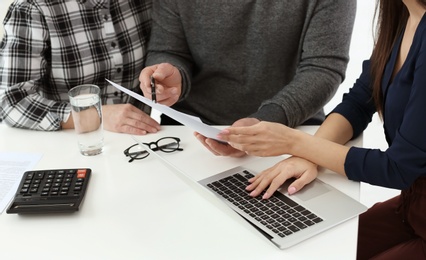 Photo of Mature couple discussing pension with consultant in office