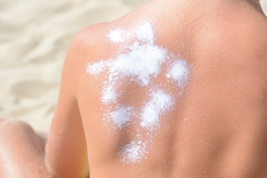 Photo of Child with sunscreen on back at beach, closeup