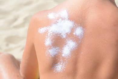 Child with sunscreen on back at beach, closeup