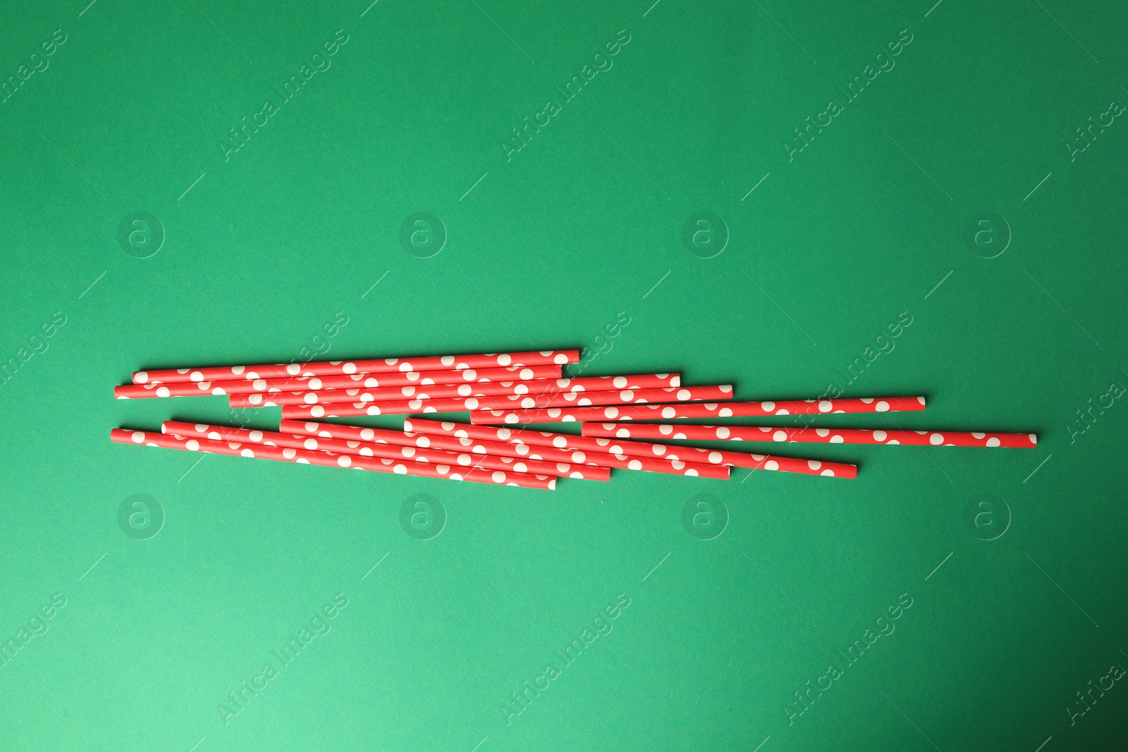 Photo of Paper drinking straws on green background, flat lay