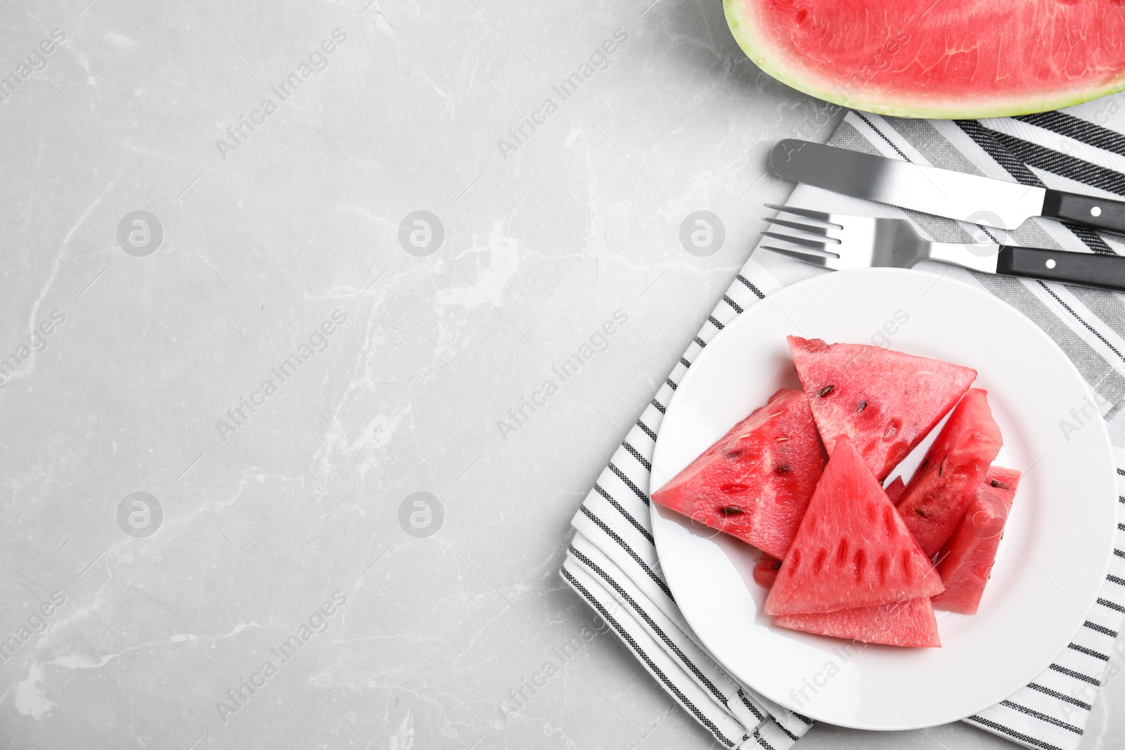 Photo of Yummy cut watermelon on grey table, flat lay. Space for text