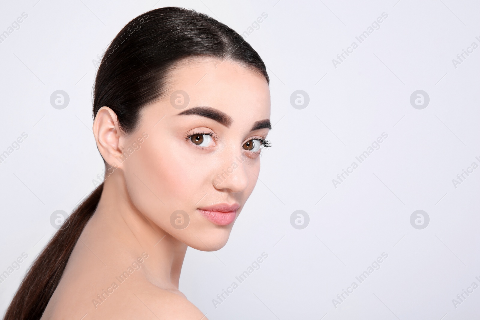 Photo of Beautiful woman with perfect eyebrows on light background