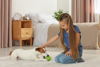 Photo of Cute girl playing with her dog in bedroom at home. Adorable pet