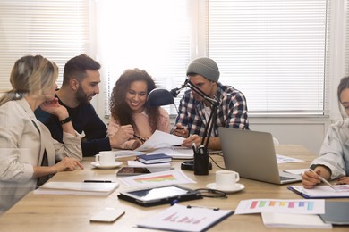 Photo of Team of employees working together in office. Startup project