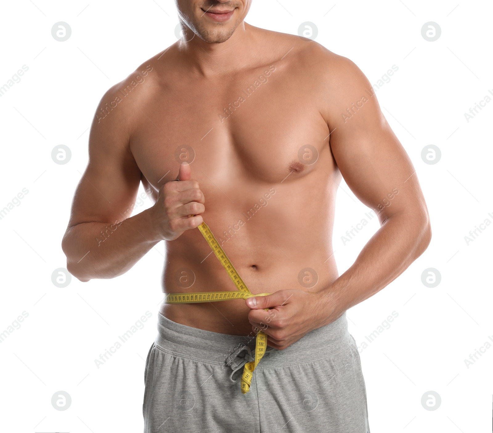 Photo of Young man with slim body using measuring tape on white background, closeup view