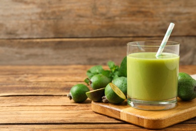 Photo of Fresh feijoa smoothie and fresh fruits on wooden table. Space for text
