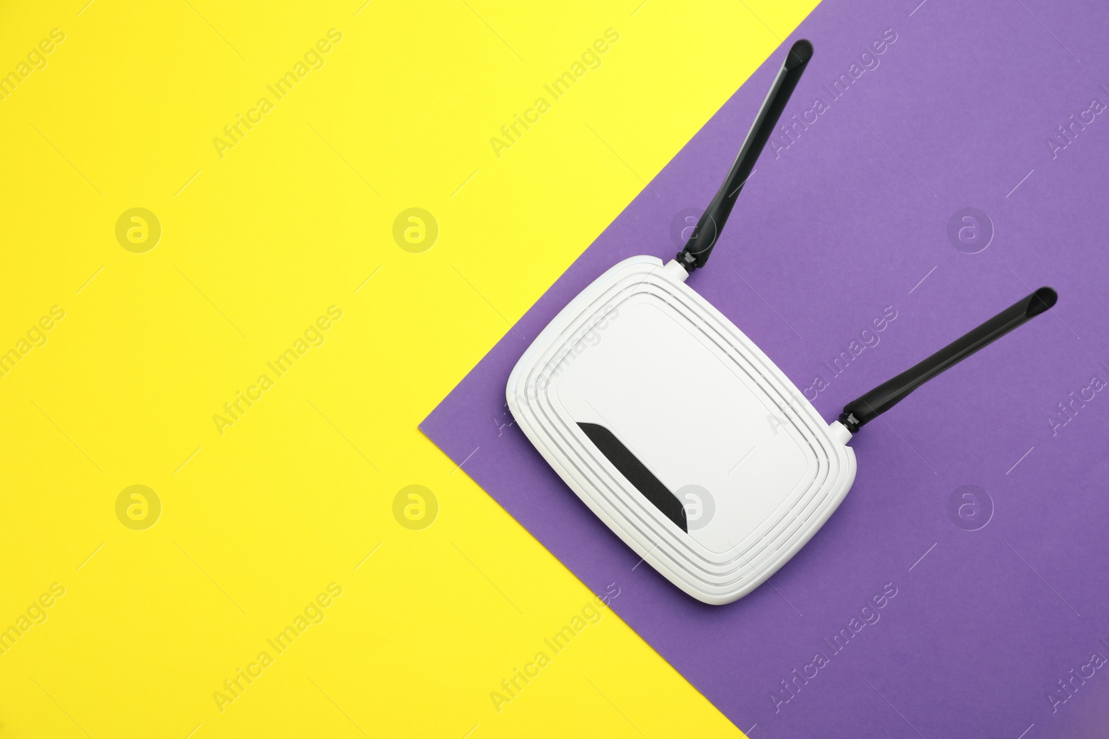 Photo of Modern Wi-Fi router on color background, top view. Space for text