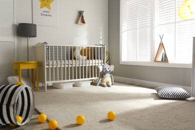 Cute baby room interior with crib and decor elements