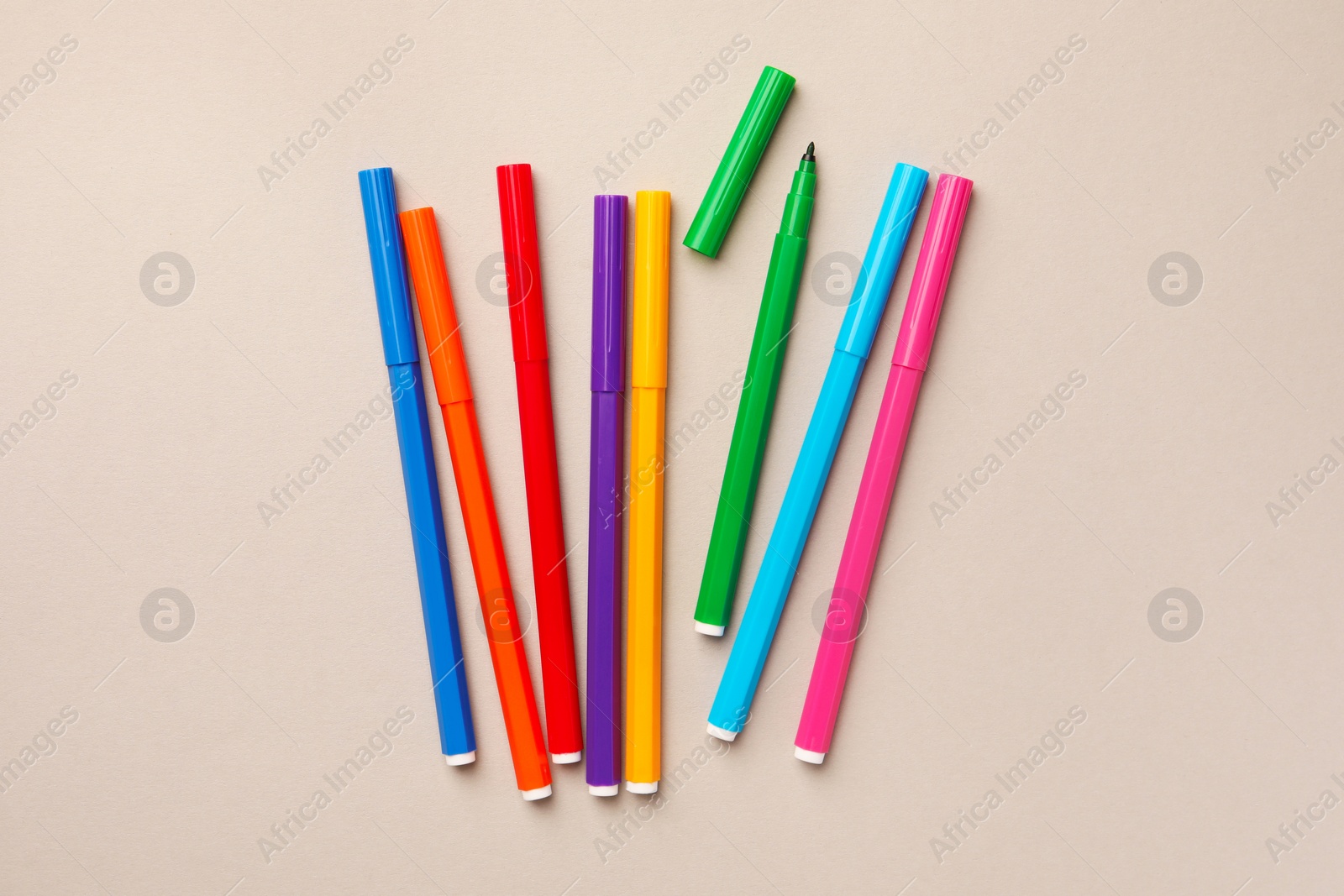 Photo of Many bright markers on light grey background, flat lay