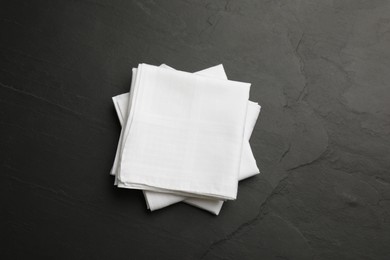 Photo of White handkerchiefs folded on black table, top view